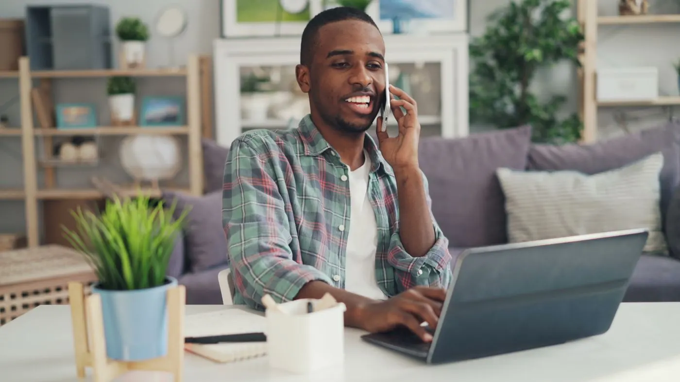Dono de pequeno negócio mexendo no celular no escritório
