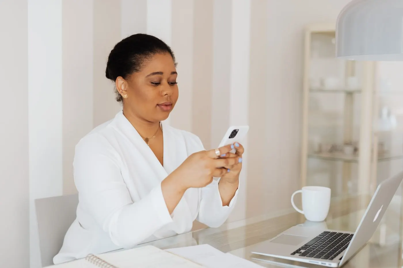 Dona de pequeno negócio mexendo no celular no escritório