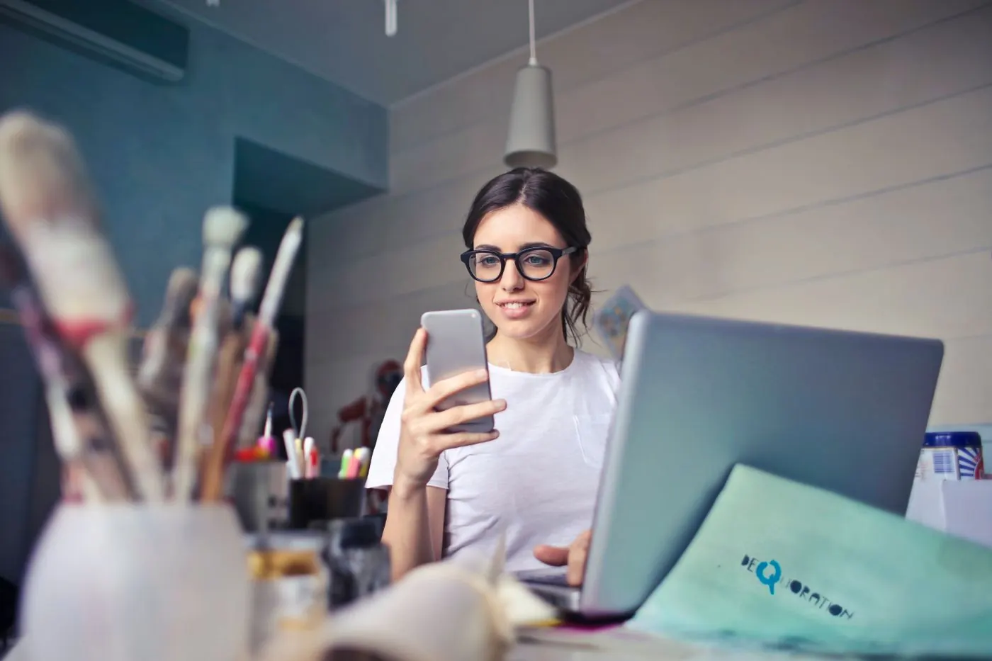 Dona de pequeno negócio mexendo no celular no escritório